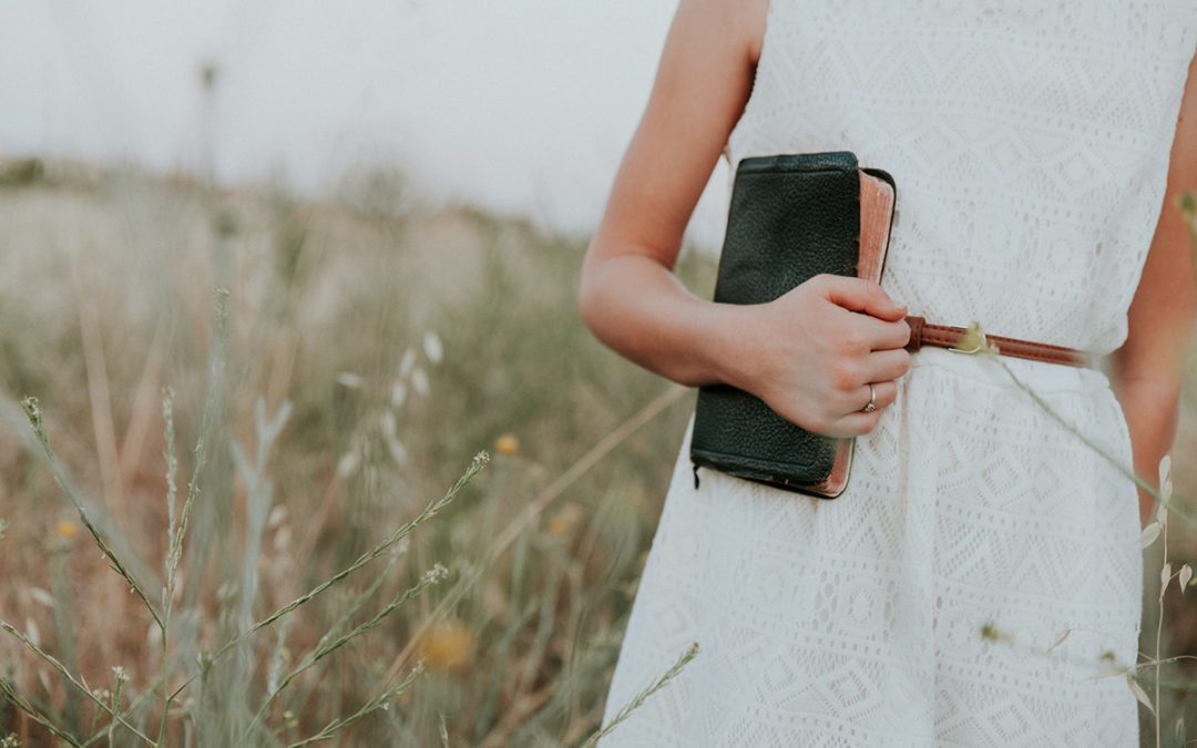 woman in field with bible